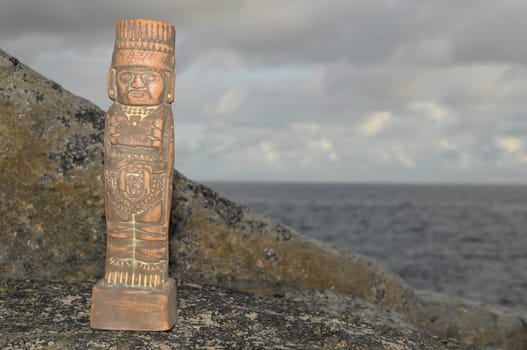 Ancient Maya Statue on the Rocks near the Ocean