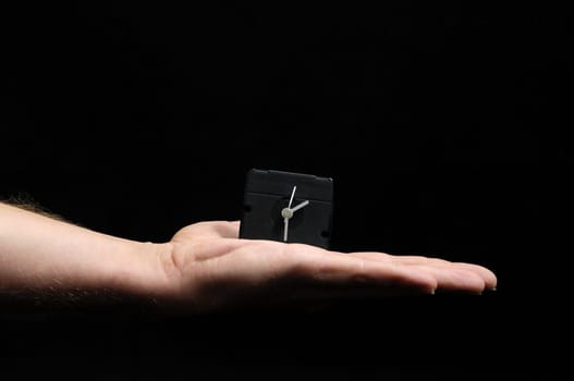 Clock And an Hand on a Black Background
