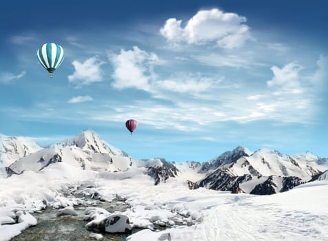 Snowfield with stream and mountain landscape with hot air balloon flying in the sky