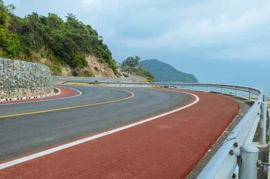 Asphalt road along a tropical sea coastline in Thailand