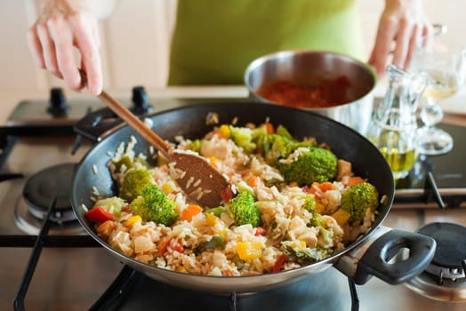 Woman cooking risotto on stove close up shoot
