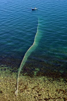 Fisherman lifting fishing net shoot from top