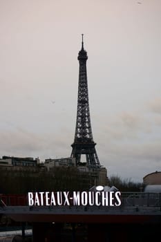 Paris,France -- January 01,2014: The Eiffel Tower and the Bateaux Mouches boat cruise docks in twilight on January 1,2014 in Paris.