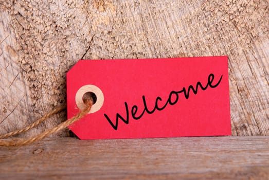 A Red Tag with the Word Welcome on Wood