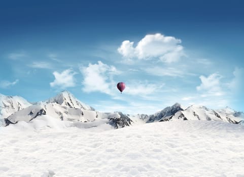 Snowfield and mountain landscape with hot air balloon flying blue sky