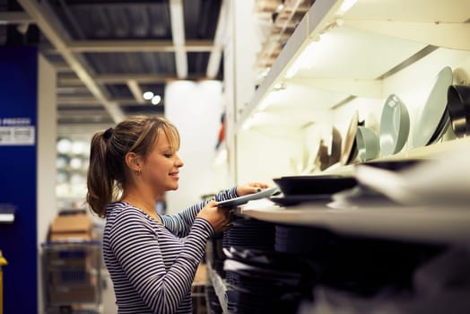 young hispanic woman shopping for furniture, glasses, dishes and home decor in store