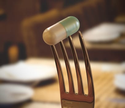 Inside the restaurant with a pill stuck in the fork. Concept of food supplement.