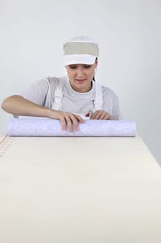 Woman rolling out wallpaper