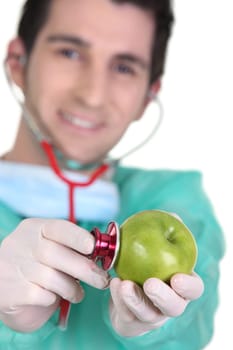 Doctor listening to apple heartbeat with stethoscope