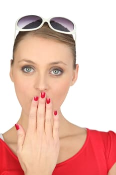 Shocked blond woman covering her mouth