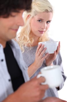 Young woman holding a  bowl with man in the foreground