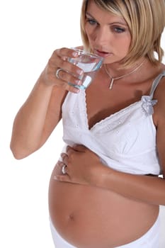 Pregnant woman drinking a glass of water