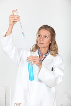 female biologist holding pipette and test tube