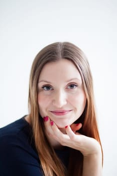 Closeup studio portrait of face of happy smiling attractive woman wearing blue blouse and resting chin on hand