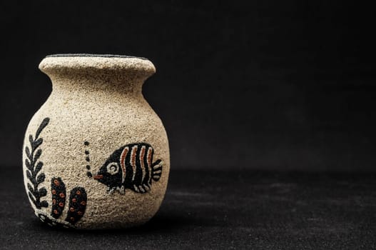Colorful designed clay vase over a Black background