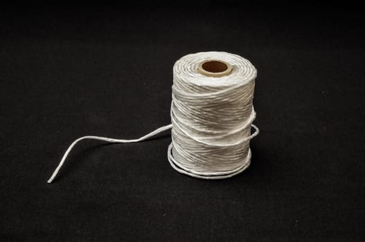 Roll of White Twine on a Black Background