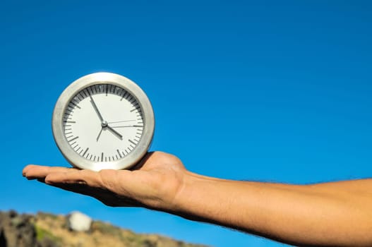 Time Concept White Sand Hourglass on the Volcanic Rocks