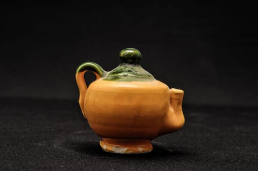 Colorful designed clay vase over a Black background