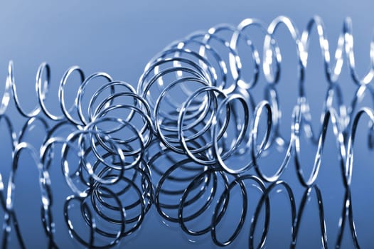 two interlocking chrome spirals bent on a blue background