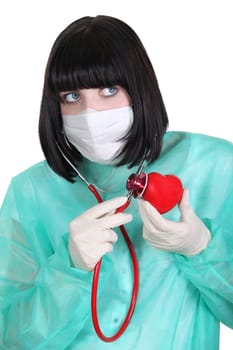 Doctor listening to a plastic heart with a stethoscope