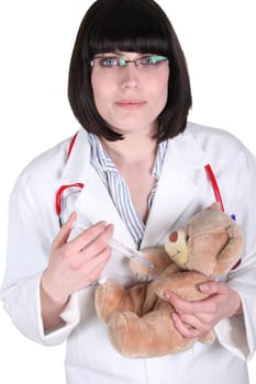 Female doctor injecting teddy bear