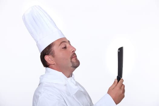 Chef looking at his reflection in a knife