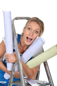 Happy woman with rolls of wallpaper