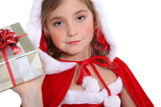 Little girl in Christmas outfit offering a present