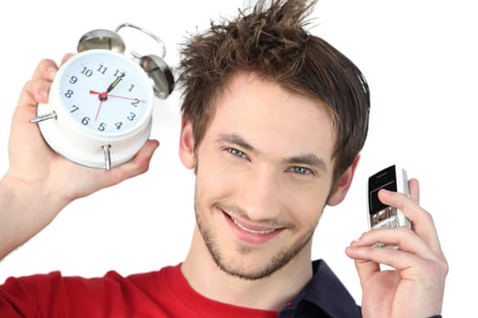 Man holding alarm clock and mobile