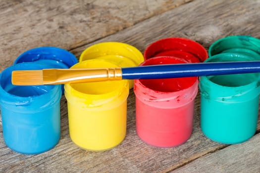 Watercolor paints with  paintbrush on the wood background