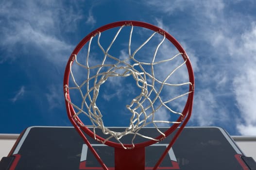 New basketball hoop from below against a cloudy sky
