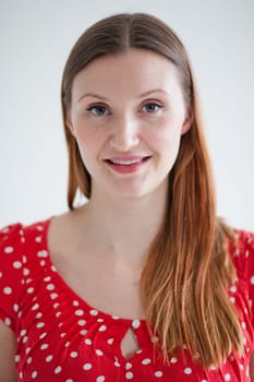 Studio portrait of happy smiling attractive woman wearing spotty red blouse