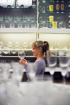 young hispanic woman shopping for furniture, glasses, dishes and home decor in store