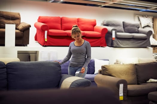 young hispanic woman shopping for furniture, sofa and home decor in store