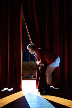 Arts and entertainment in theatre with funny man working as anchorman, standing with pants behind the scenes and looking at pit