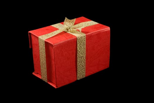 Gift box with golden ribbon isolated over black