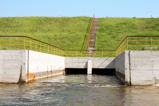 Water flowing over floodgates of a small dam