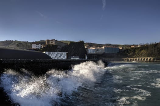 Beautiful splashing wave in to the wall, at Getaria city in Spain