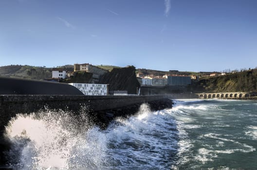 Beautiful splashing wave in to the wall, at Getaria city in Spain