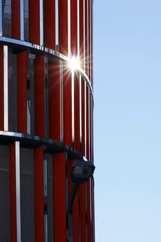 The close-up of a modern wall covering with a sun reflection and lantern.