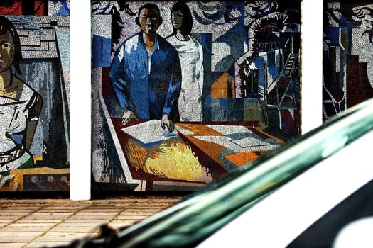 Potsdam,Germany – August 11,2012: The mosaic painting "Man Conquers the Cosmos"" by FRITZ EISEL on a wall of houses in Potsdam with a passing car on August 11,2012 in Potsdam."