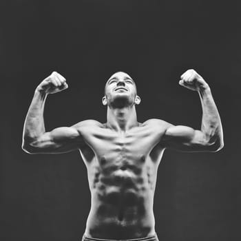 Image of shirtless man looking upwards with raised arms in front of camera
