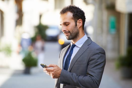 Happy people with businessman on the phone typing text message in city street