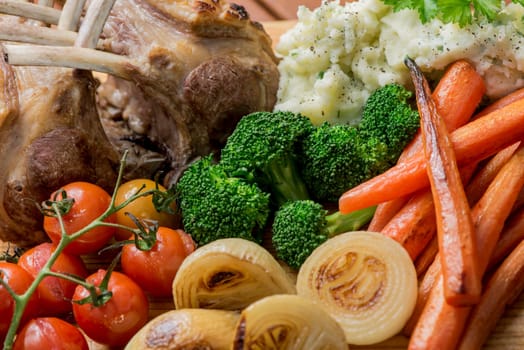 Roast Rack of Lamb with roasted mixed vegetables, onions, carrots, tomatoes, broccoli and mashed potato