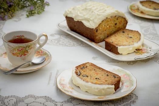 Beautiful and delicious homemade carrot cake on antique tableware with a cup of tea