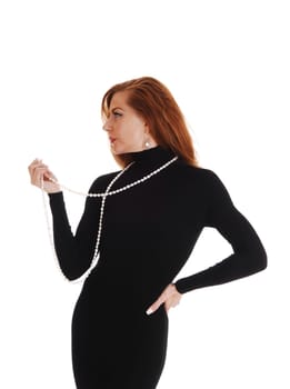 A middle aged woman standing in profile in a black dress isolated for.white background..