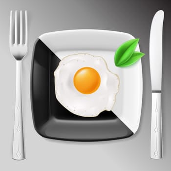 Served breakfast. Fried egg on black and white plate served with fork and knife