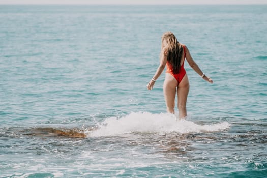 Woman sea yoga. Back view of free calm happy satisfied woman with long hair standing on top rock with yoga position against of sky by the sea. Healthy lifestyle outdoors in nature, fitness concept.