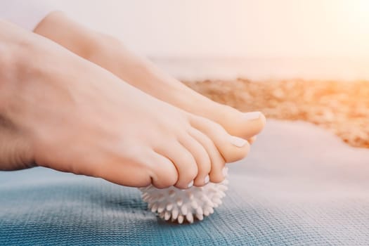 Woman yoga sea. Well looking middle aged woman with braids dreadlocks in white leggings and tops doing stretching pilates on yoga mat near sea. Female fitness yoga routine concept. Healthy lifestyle