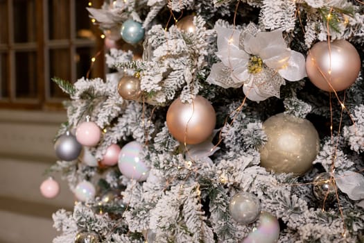 Christmas holiday composition. Christmas tree fir branches, silver balls on top border on pink pastel background with copy space.